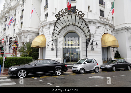 Mercedes Benz and Smart cars parked in front of entrance to Art Deco Hotel Negresco on the Promenade des Anglais Nice France Stock Photo