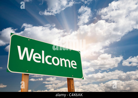 Welcome Green Road Sign Against Clouds and Sunburst. Stock Photo