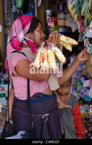 An ethnic hill tribe woman living in poverty is shopping at a food market in communist Laos. Stock Photo