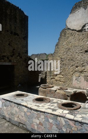 The Grande Taberna, an ancient pub with amphorae set into marble counters used for storing food & drink, Herculaneum, Italy. Stock Photo