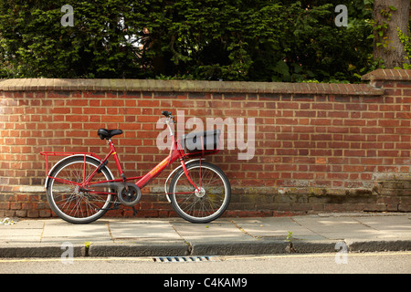 A Royal Mail bicycle leaning against a brick wall