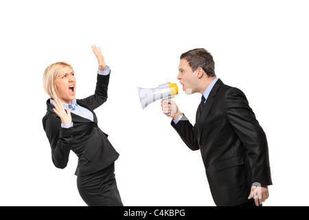 Angry businessman yelling via megaphone to a businesswoman Stock Photo