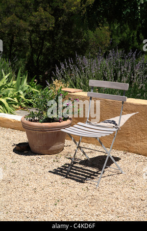Traditional french folding garden chair in domestic garden in Provence France mistral wind blowing cushion windy day Stock Photo