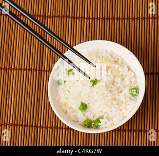 A bowl of egg fried rice with a pair of chopsticks in shoot Stock Photo