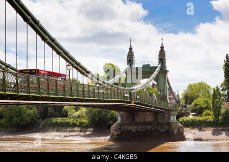 London Bus crossing Hammersmith Bridge over the River Thames, London, England, UK Stock Photo