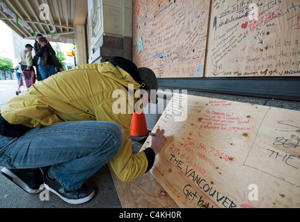 Man writing message on board in aftermath of Vancouver hockey riots in 2011 Stock Photo