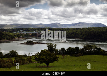 Looking across The Menai Strait (Afon Menai) from Anglesey towards the Menai Bridge and the mountains of Snowdonia, Wales Stock Photo