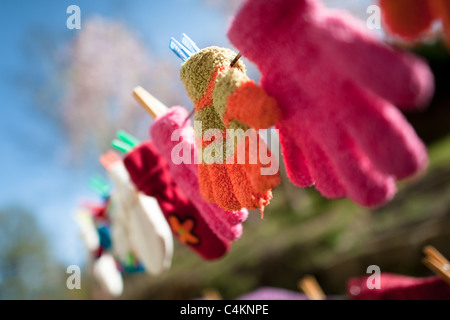 Colorful kid gloves hanging on a clothes line in the backyard of an apartment house, Czech Republic. Stock Photo