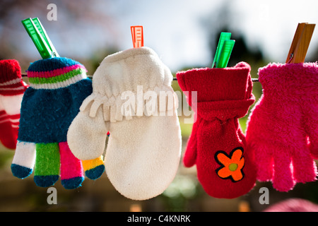 Colorful kid gloves hanging on a clothes line in the backyard of an apartment house, Czech Republic. Stock Photo