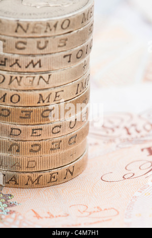 Closeup of Stack / Pile of One Pound Coins on top of Ten Pound Notes Stock Photo