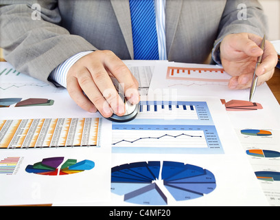 Businessman analyzing investment charts at his workplace Stock Photo