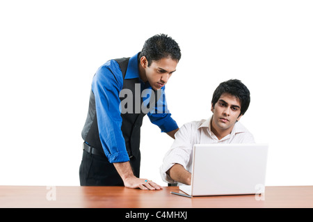 Two professional men working on the same desk. Stock Photo