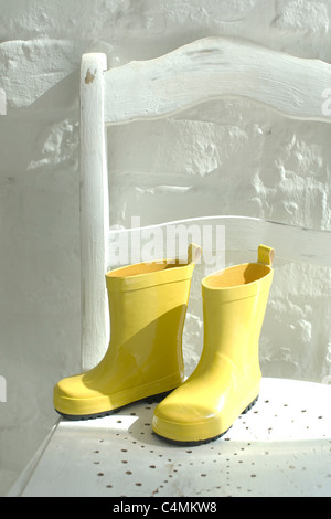 bright yellow rubber boots on the feet of a child Stock Photo - Alamy