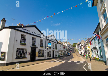 Horizontal wide angle view of a typical British village High Street decorated with bunting and Union Jack flags on a sunny day. Stock Photo