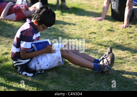 little boy reads a book at the Hay Literary Festival, May 2011 Stock Photo