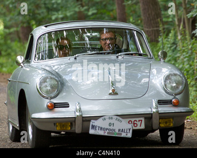 Silver Porsche 356 coupe driving on a forest lane in Belgium Stock Photo