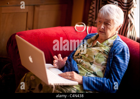 an 80 year old woman using her laptop computer to keep in touch with her friends and family, UK Stock Photo