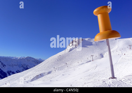 Giant yellow pin landmark on the piste in Fieberbrunn, Austria Stock Photo