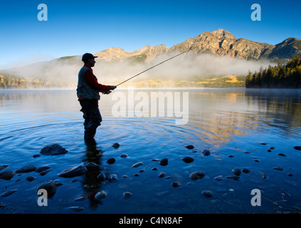 Middle age male fly fishing in Pyramid Lake, Jasper National Park, Alberta, Canada.