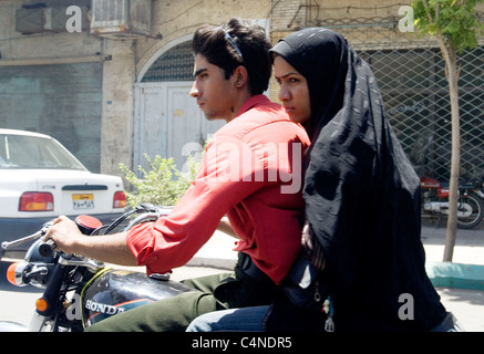 Young Iranian man and woman riding Honda motorcycle in Yazd, Iran Stock Photo