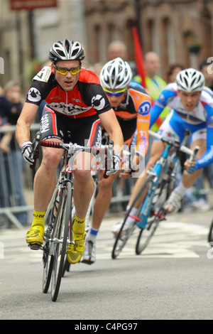 Professional cyclists competing in town centre road race Stock Photo