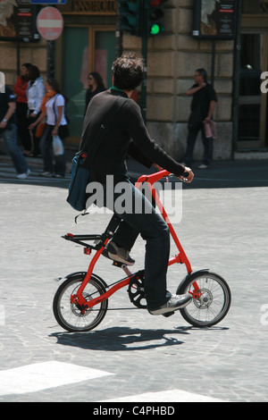 man with small miniature folding bike in rome italy Stock Photo