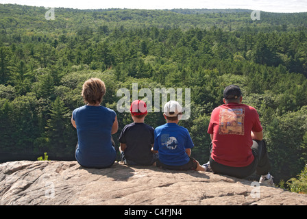 Family sitting on top of Bon Echo Rock, Bon Echo Provincial Park, Ontario, Canada Stock Photo