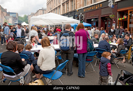 People eating at street tables, Gibson Street Gala, part of Glasgow's  West End Festival. Stravaigan restaurant in background. Stock Photo