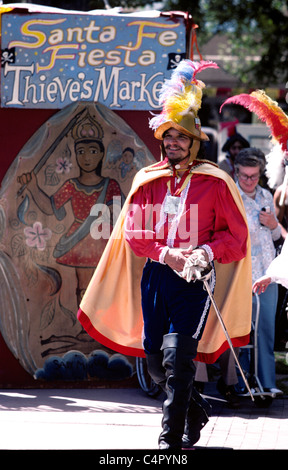King of fiesta De Santa Fe enters thieves market in Spanish soldiers clothes with plumed  hat cape and sword Stock Photo