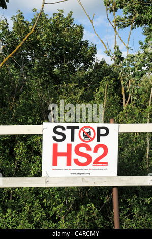 Stop HS2 High Speed Rail 2 Sign attached to a Wooden Fence with Trees and Blue Sky in Background Stock Photo