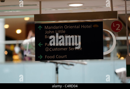 Sign in Marina Bay shopping mall pointing to the Pan Pacific Hotel and Mandarin Oriental Hotel plus a food court Stock Photo