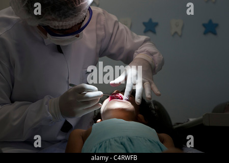 8-years old girl at dentist´s chair receiving dental care. Good hygiene practices. Manaus, Amazonas State, North Brazil. Stock Photo