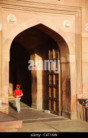 Boy walking through doorway of Jehangir's Palace in Agra Fort, Agra, Uttar Pradesh, India Stock Photo