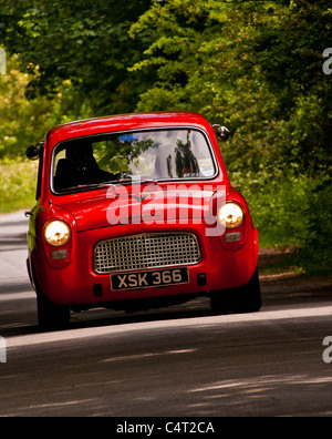 Renovated classic car 1959 Ford Anglia 100E driving in English country lane Stock Photo