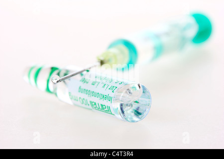 Injection cannula, medical syringe, filling a syringe with a medicament from a vial. Stock Photo
