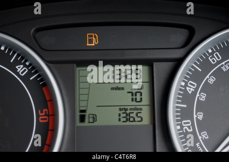 Car dashboard showing low fuel warning light Stock Photo