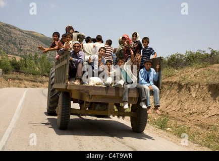 People riding a tractor in northeastern Iran Stock Photo