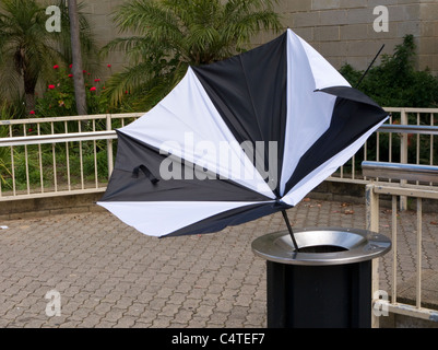 Umbrella blown inside-out in a rubbish bin Stock Photo