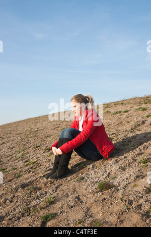Teenager Sitting on Ground Stock Photo
