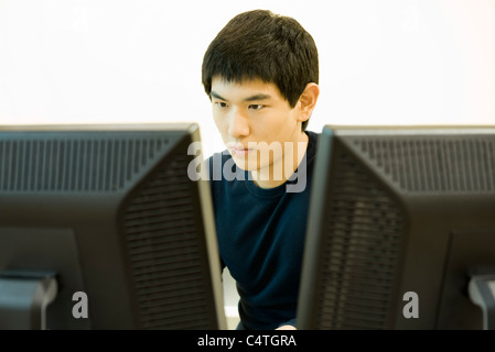 Young man working on computer with two monitors Stock Photo