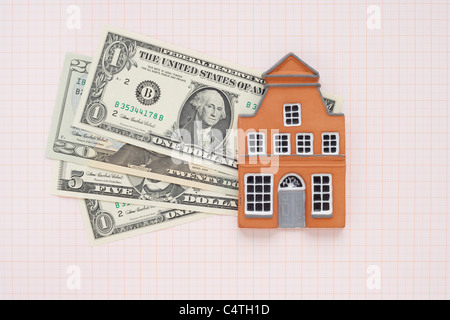 House and American Currency on Graph Paper Stock Photo