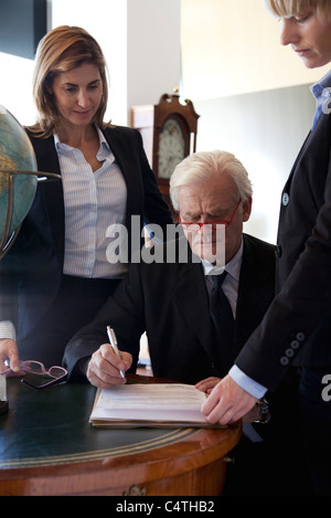 Executive examining documents, colleagues by his side Stock Photo