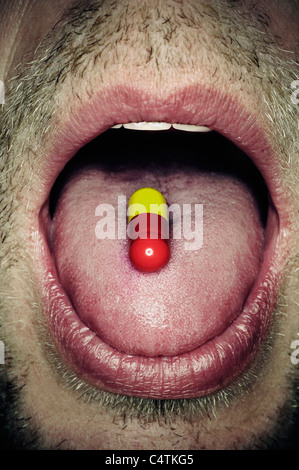 Capsule on man's tongue, close-up Stock Photo