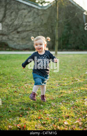Toddler girl playing outdoors Stock Photo