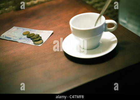 Empty coffee cup and money on table Stock Photo