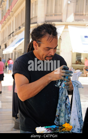 Artist painting on glass along Calle Larios (shopping street), Malaga, Costa del Sol, Andalucia, Spain, Western Europe. Stock Photo