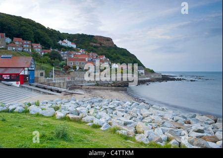 Quaint coastal village (cliffs, attractive cottages, sandy beach, calm sea, slipway, lifeboat station) - Runswick Bay, North Yorkshire, England, UK. Stock Photo