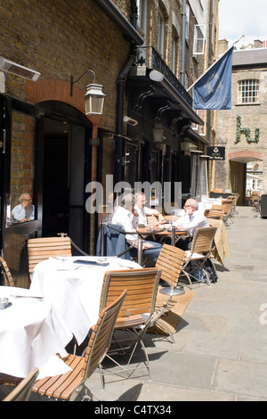 London Mayfair Lancashire Court Mews restaurant with diners outside enjoying the sun peace yards from Bond Street sign Art Gallery Stock Photo