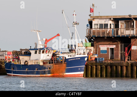 Bridlington harbour in evening sun (fishing boat moored, men working on  quay, fish market business) - scenic North Yorkshire Coast town, England, UK. Stock Photo