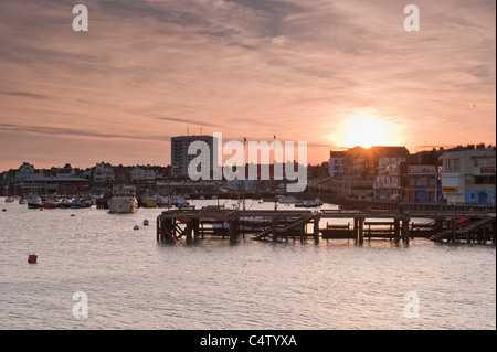 Bridlington harbour at sunset (fishing boats & pleasure craft moored, jetty,  sea, red sky over town) - scenic North Yorkshire Coast town, England, UK